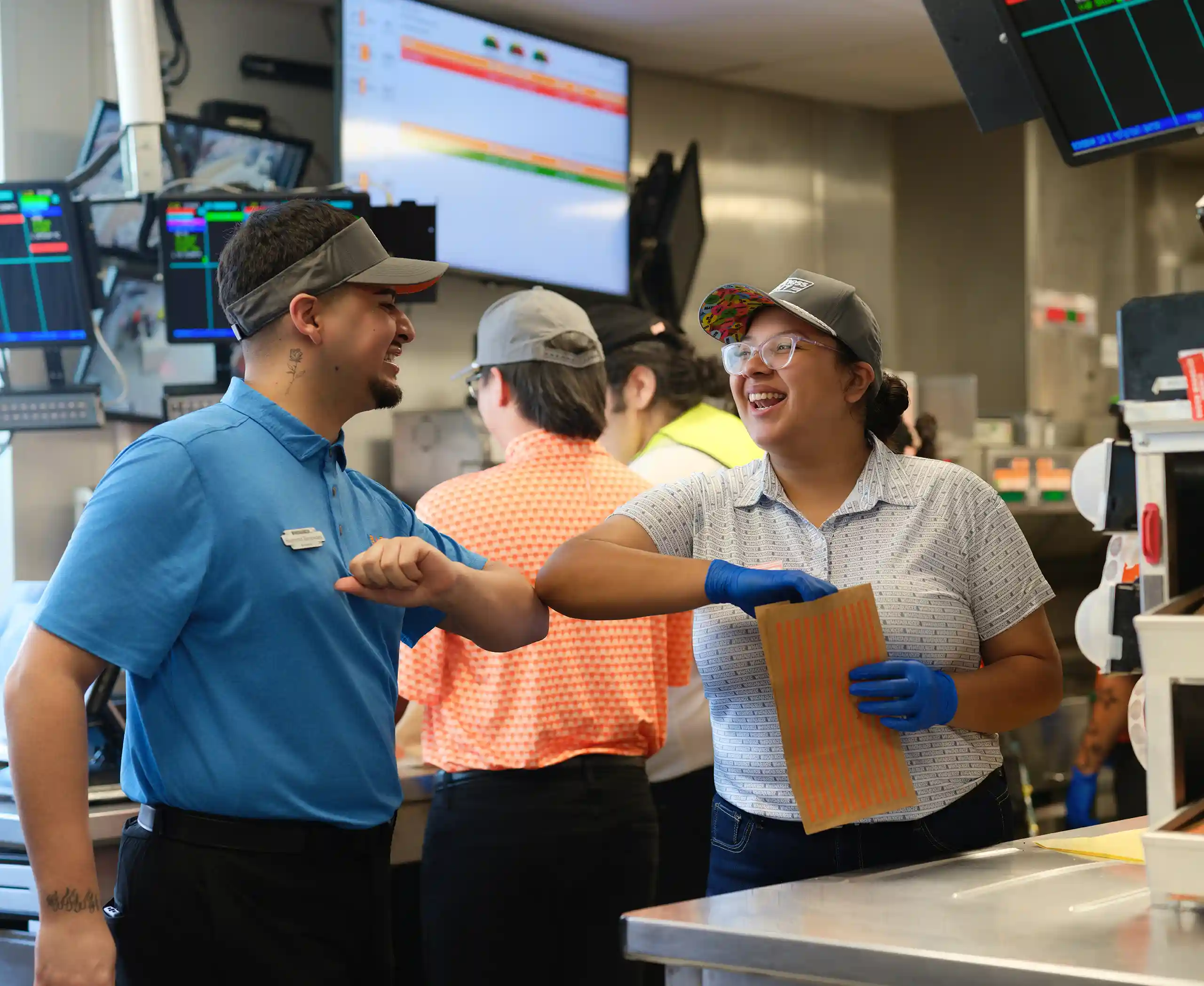 Whataburger employees collaborating inside a Mississippi restaurant during food preparation and customer service.
