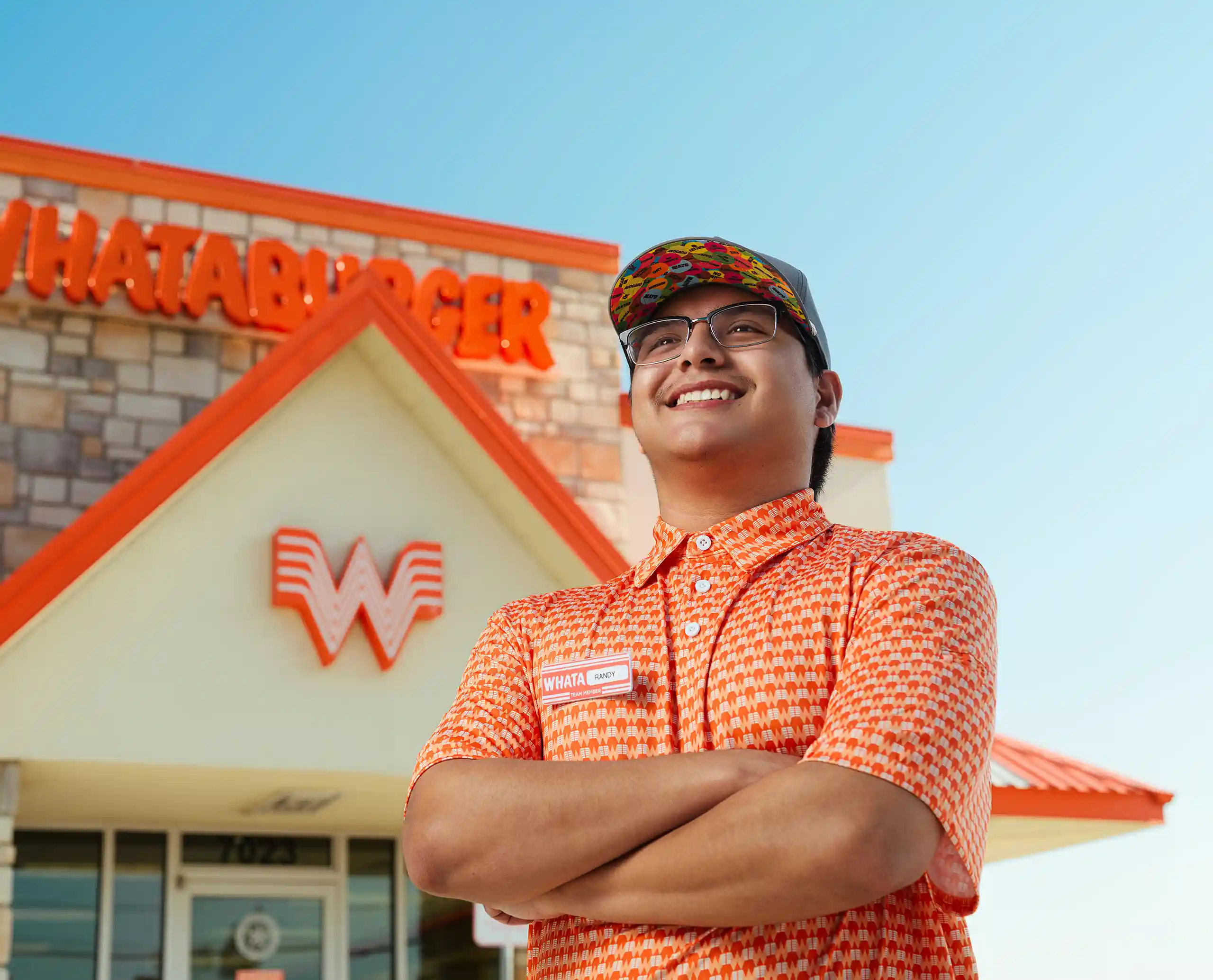 Smiling Whataburger team member standing outside a Whataburger restaurant in Mississippi.