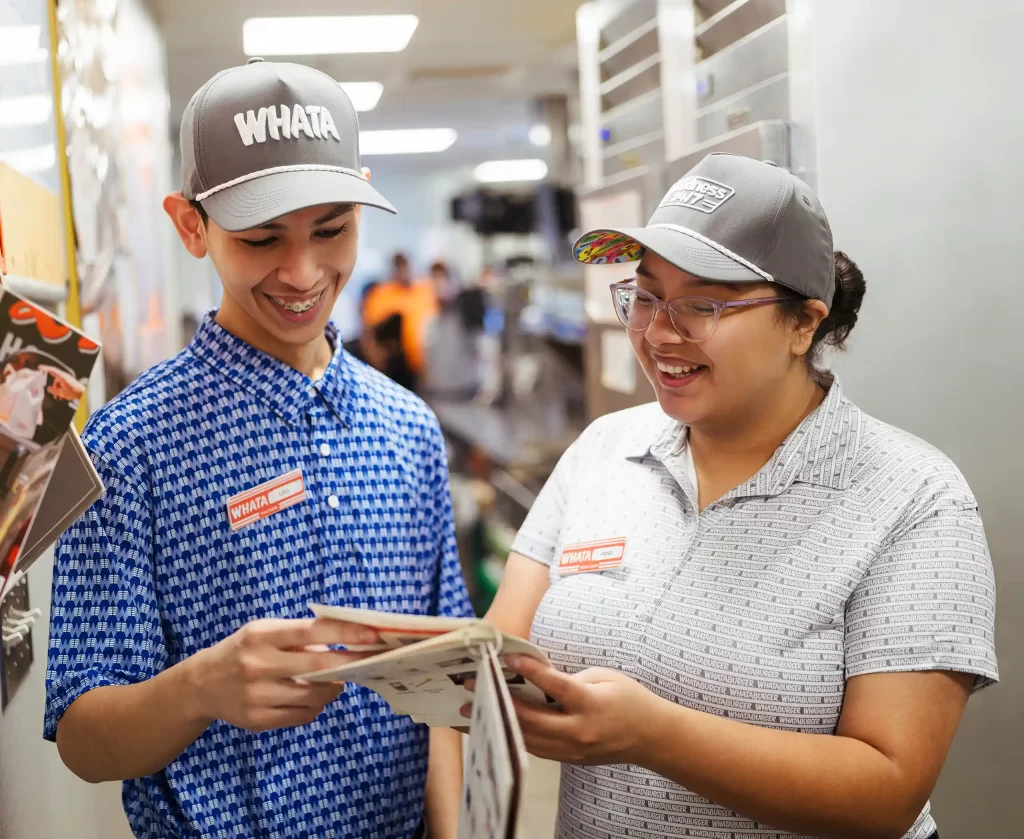 Two Whataburger team members reviewing training materials together inside a Mississippi restaurant.